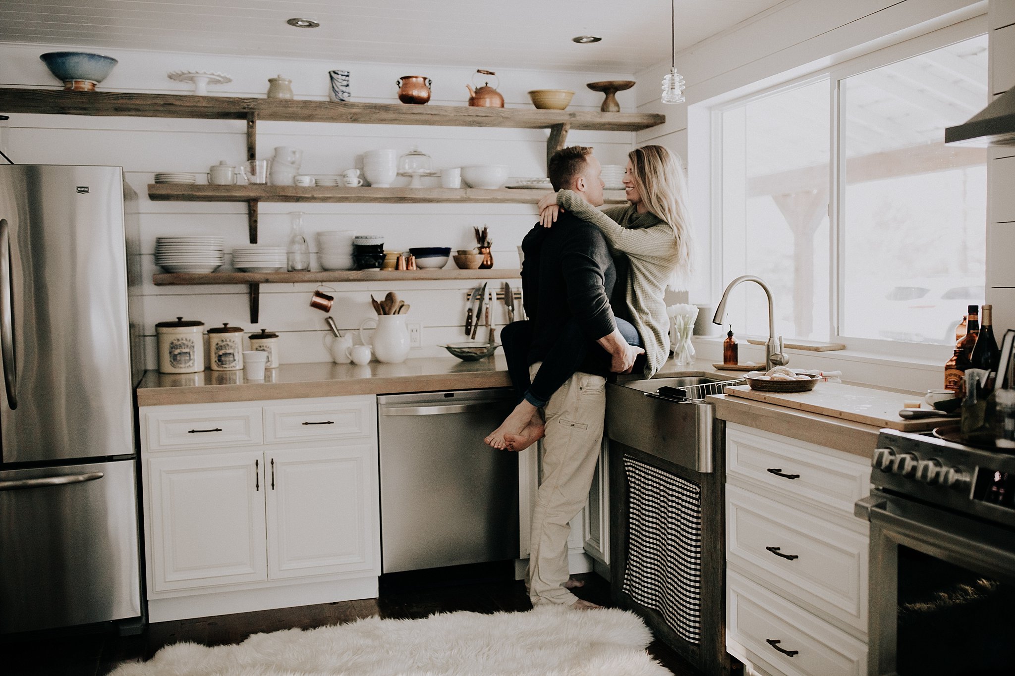Couple sitting on counter in farmhouse