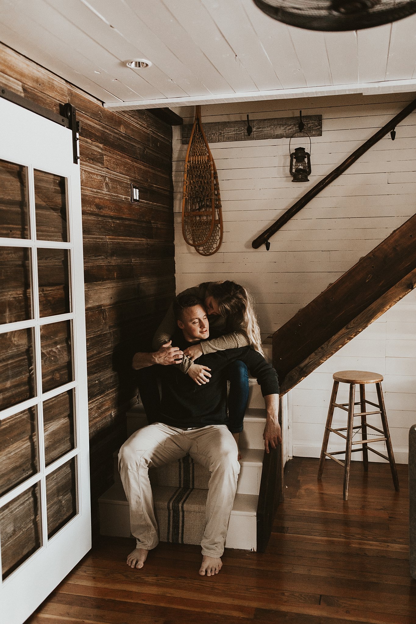 Couple sitting on stairs in farmhouse