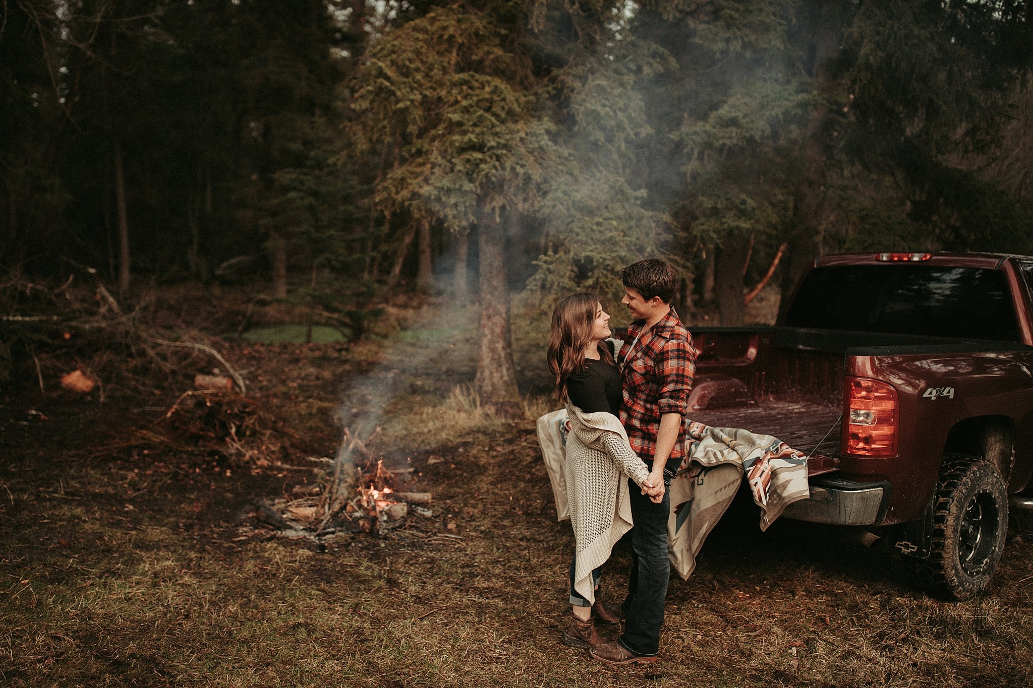 Moody couples session by a campfire