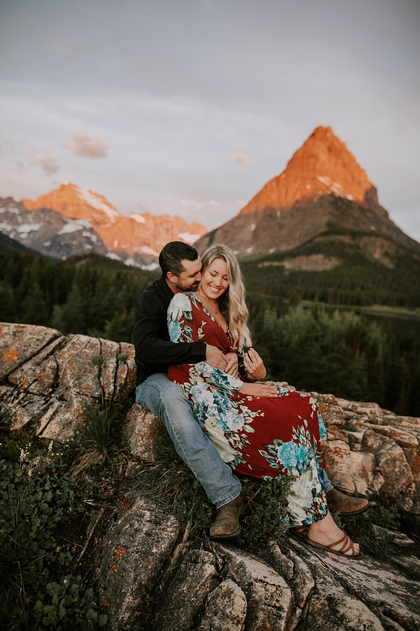 couples sitting in the mountains for sunrise